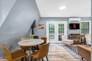 A modern living room with a fireplace, a TV, and a cozy seating area.