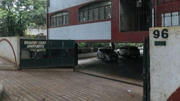 A gated entrance to a building with a sign indicating 'Broadway Court Apartments.'