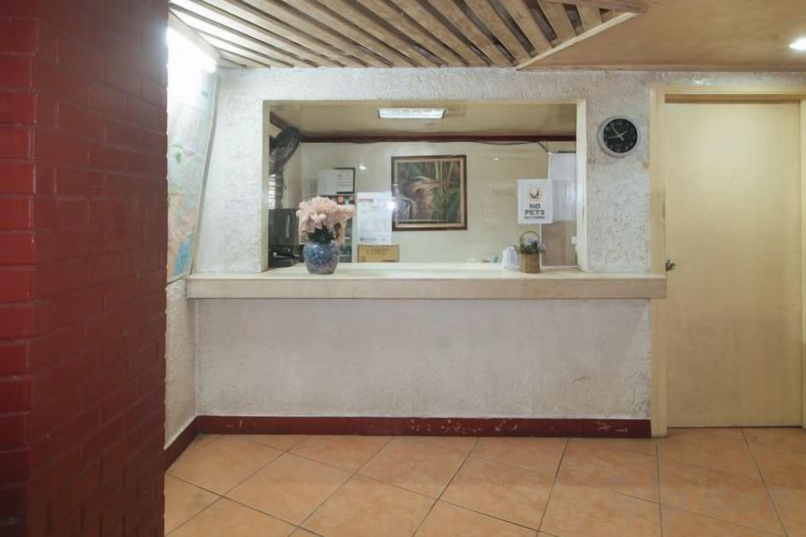 A reception area with a reception desk, a clock, and a door.