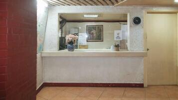 A reception area with a reception desk, a clock, and a door.