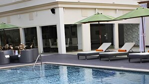 Une piscine avec des chaises longues et des parasols.