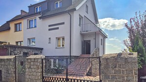 A two-story house with a stone gate, a balcony, and a visible number '10' on the side. - 2 bedroom cozy home in Szczecin (Szczecin)