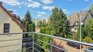 A residential area with a mix of single and multi-story buildings, a paved driveway, and a variety of trees. - 2 bedroom cozy home in Szczecin (Szczecin)