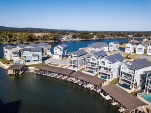 A waterfront residential area with multi-story houses, docks, and a clear view of the lake.