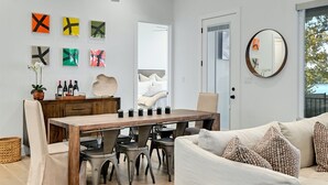 A spacious living room with a wooden dining table, a white sofa, and a hanging light fixture. - Packsaddle Point Luxury Lakefront w/Pool+Guest House (Kingsland)
