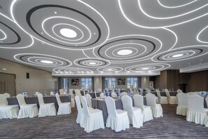 A conference room with a modern ceiling design, white chairs, and tables arranged for a meeting. - Hangzhou West Lake Enjoyor Hotel (Hangzhou)