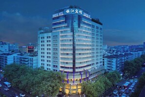 A multi-story hotel with a curved facade, multiple balconies, and a prominent entrance. - Hangzhou West Lake Enjoyor Hotel (Hangzhou)