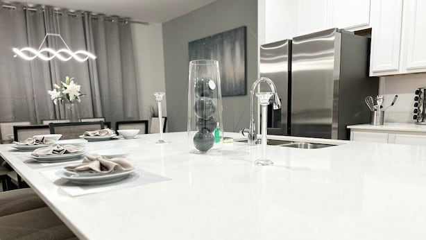 Eine moderne Küche mit einer großen Kochinsel, Edelstahlgeräten und minimalistischem Design.