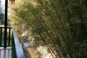 A view of a bamboo forest with a clear path alongside a building. - Gujia Inn (Zhaoping)
