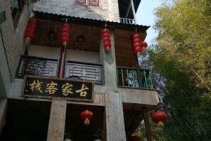 A traditional building with a signboard, balconies, and red lanterns. - Gujia Inn (Zhaoping)