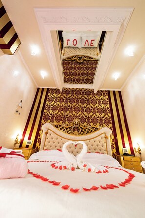 A luxurious bedroom with a large bed, ornate headboard, and a decorative ceiling. - guest house eros suite (Rome)
