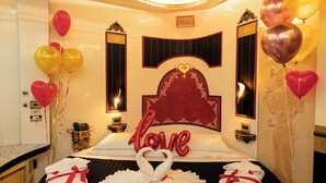 A round bed with a black and white bedspread, a red heart-shaped sign, and a mirror above it. - guest house eros suite (Rome)