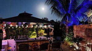 An outdoor bar area with chairs, a counter, and a palm tree. - Resort Style Tranquil Oasis in Beautiful Port Saint Lucie , Florida (Port St. Lucie)