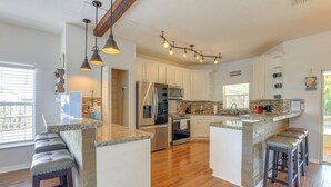 A spacious kitchen with white cabinets, a granite countertop island, and a stone backsplash. - Resort Style Tranquil Oasis in Beautiful Port Saint Lucie , Florida (Port St. Lucie)