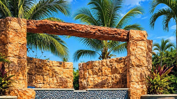 A clear pool with a stone archway, surrounded by palm trees and a clear blue sky. - Resort Style Tranquil Oasis in Beautiful Port Saint Lucie , Florida (Port St. Lucie)