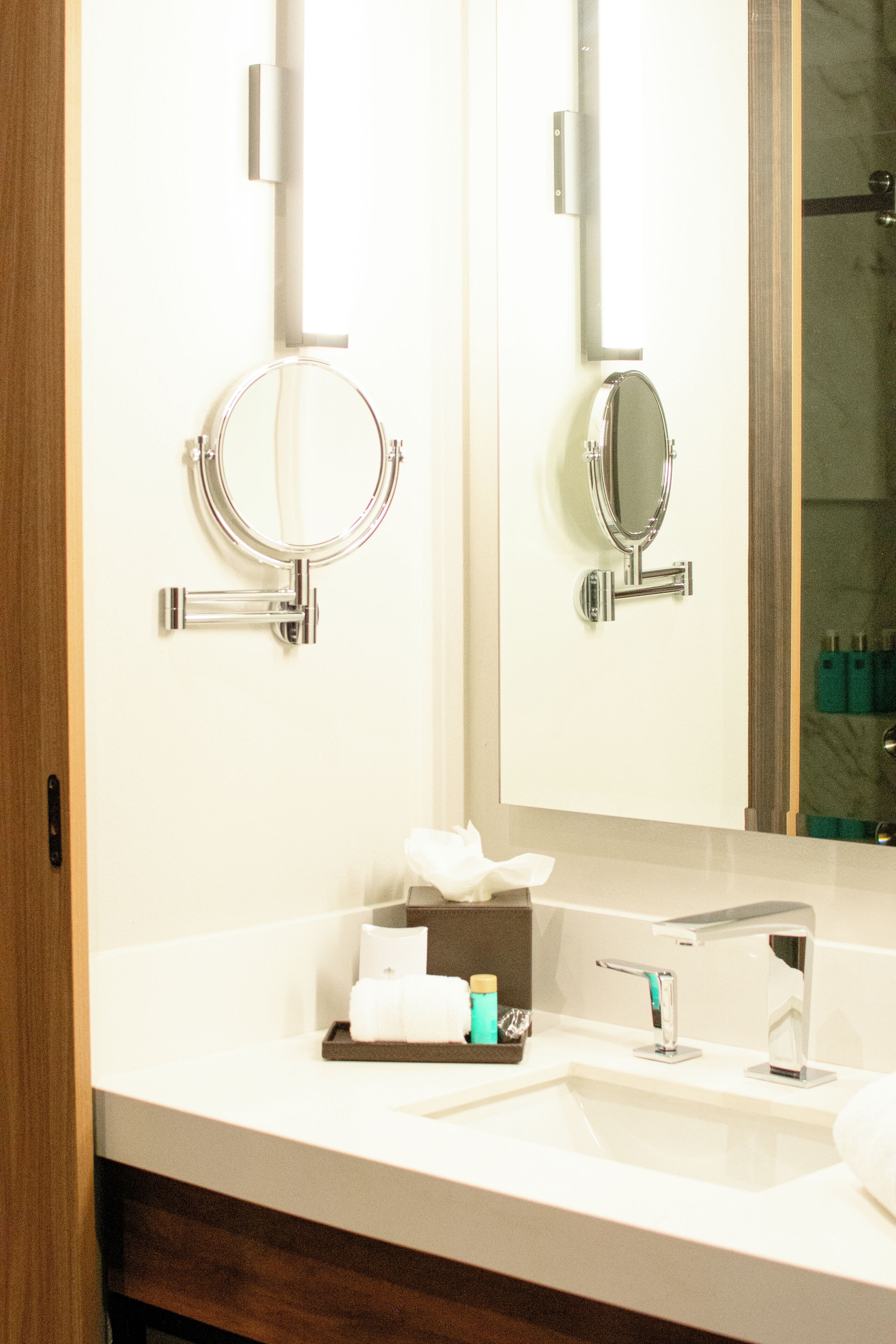 A bathroom with a white sink, a mirror, and a towel rack.
