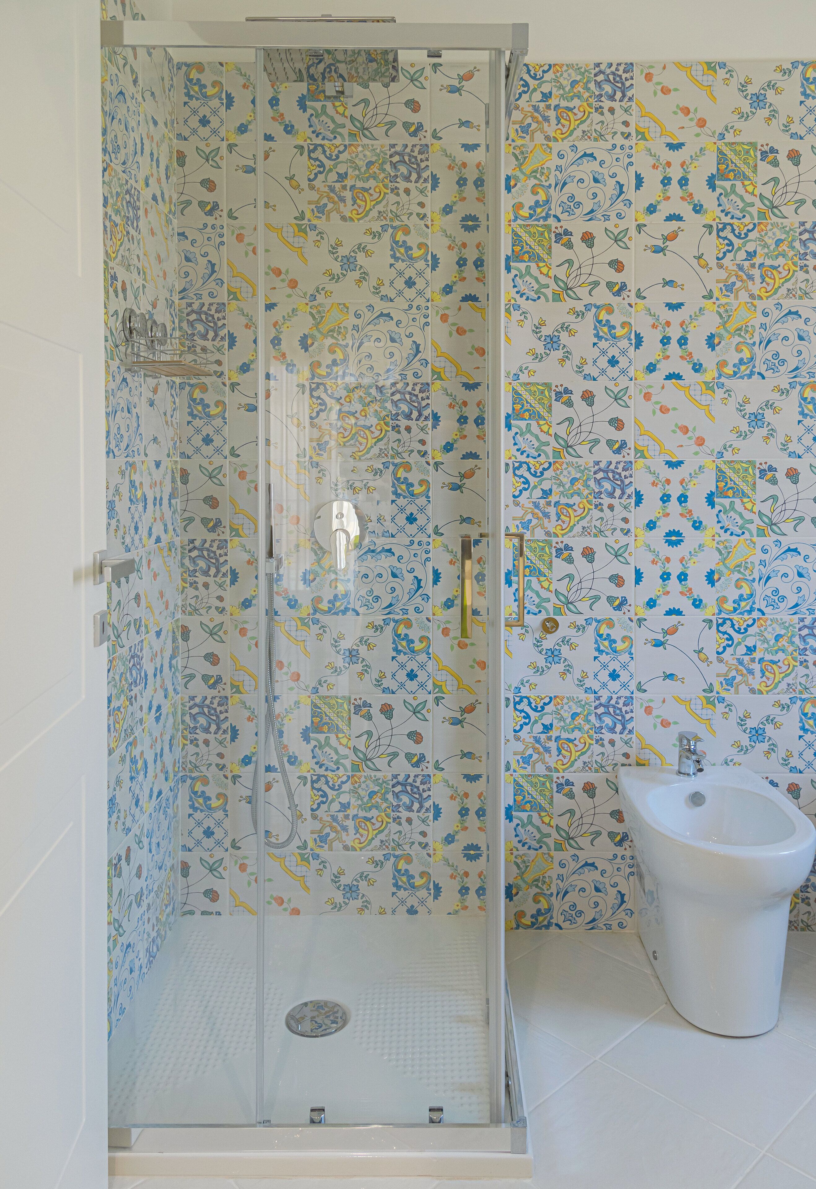 A bathroom with a shower enclosure, a toilet, and a sink.