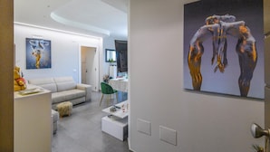 Ein modernes Wohnzimmer mit Sofa, Couchtisch und Kunstwerk an der Wand.