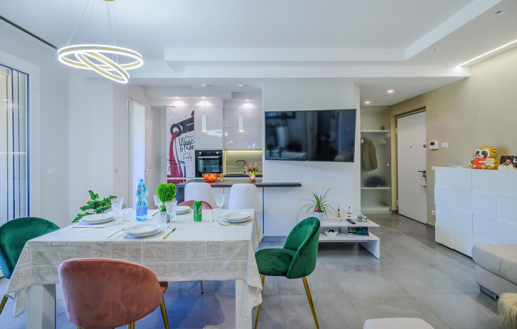 Een moderne eethoek met een tafel voor vier personen, een keuken op de achtergrond en een zithoek met een bank en salontafel.