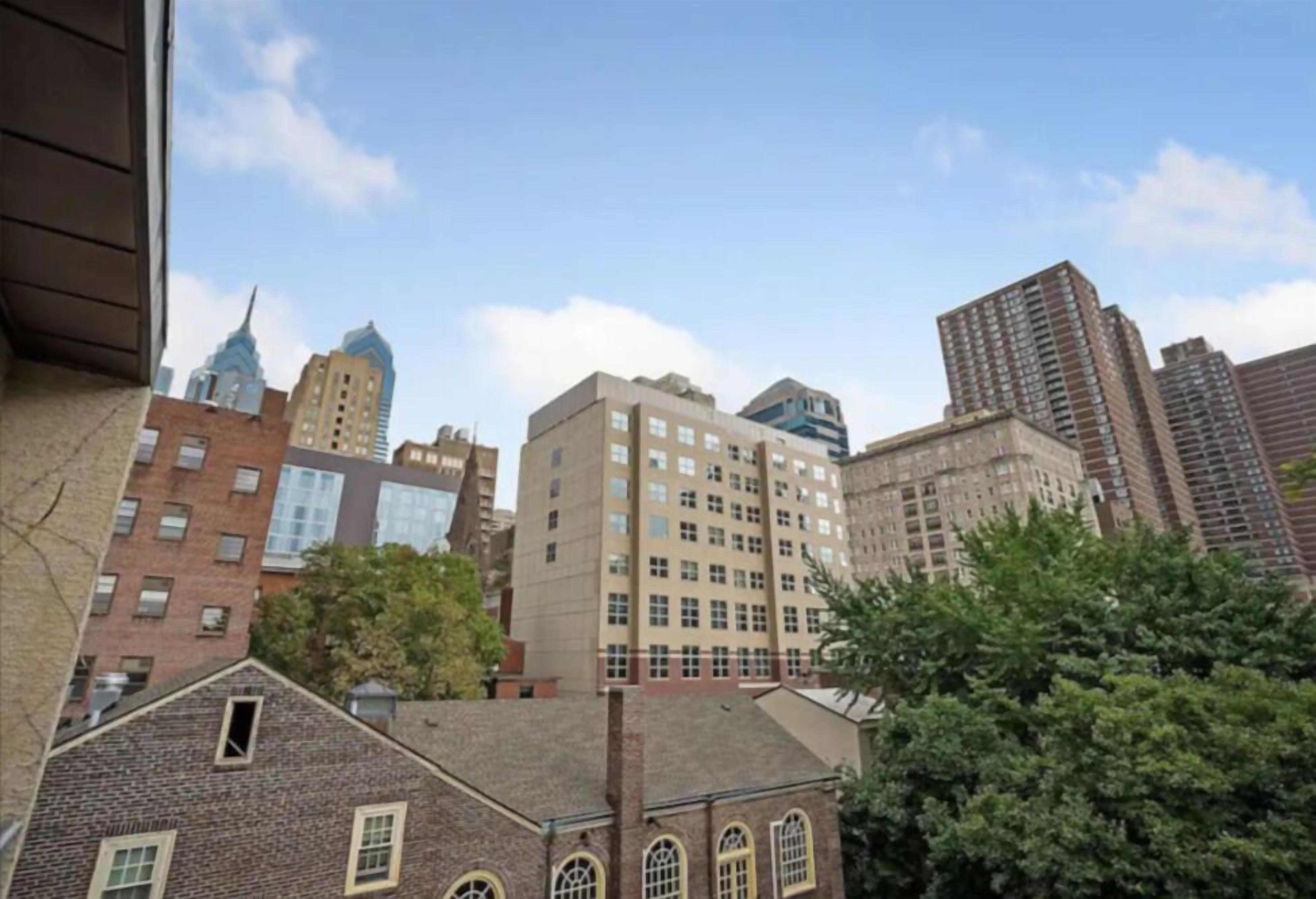 A cityscape with various buildings, including a prominent skyscraper and several mid-rise structures.