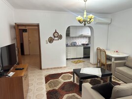 Apartamento família, 3 quartos, vista para a cidade | Área de estar | TV de tela plana