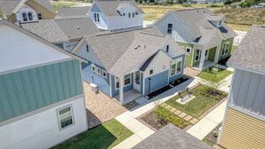 A residential area with multiple houses, each with a distinct architectural style and varying roof colors. - Magnolia Haus at Solms Landing (New Braunfels)