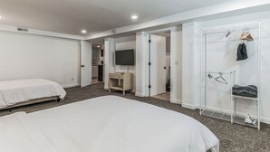 A modern hotel room with a large bed, a TV, a wardrobe, and a drying rack. - Charming 1-bedroom house in lovely Burien with  high speed WiFi,  (Burien)