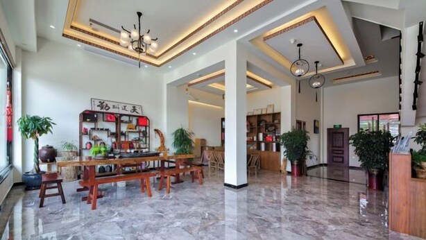 A spacious lobby with a marble floor, wooden furniture, and potted plants. - Wuyishan Hike Tea House Inn (Wuyishan)