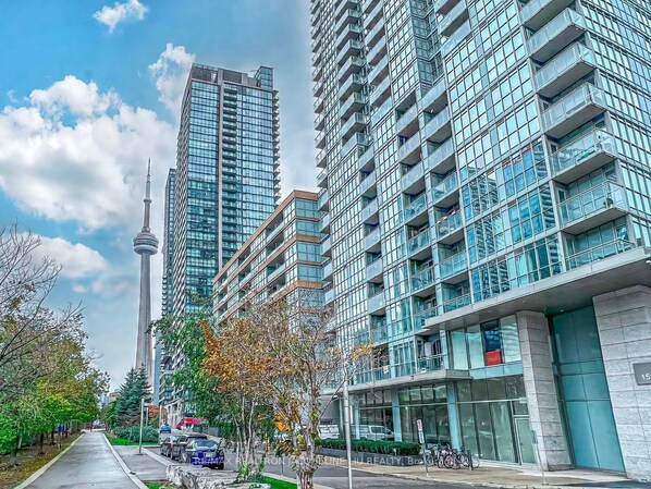 Urban streets come alive in this vibrant cityscape, lined with towering high-rise buildings and lush greenery.