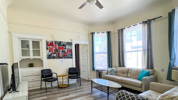 A spacious living room with a ceiling fan, a dining area with a table and chairs, and a kitchen area with cabinets and a refrigerator. - Newly Remodel Duplex Free Parking 3-Bed-1 Bath. (Sacramento)