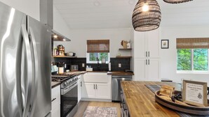 Et moderne køkken med rustfrie apparater, træbordplader og en central ø.