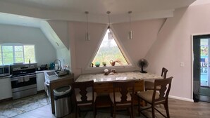 Eine Küche mit Essbereich, Mülleimer und einem Fenster mit Blick.