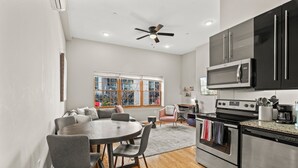 A modern kitchen with a dining area, large windows, and a ceiling fan. - 261 S 17th Street (Philadelphia)