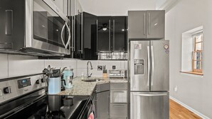 A modern kitchen with stainless steel appliances, a microwave, and a built-in oven. - 261 S 17th Street (Philadelphia)