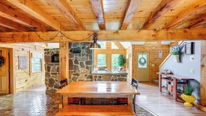 Un interno in legno con un camino in pietra, un tavolo da pranzo in legno e una parete in pietra.