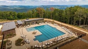 Une piscine avec des chaises longues et une vue sur les montagnes.