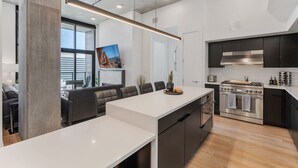 A modern kitchen with a large island, dark cabinetry, and stainless steel appliances. - Premium SLC Luxury- Penthouse VIEWS+ Top Amenities (Salt Lake City)