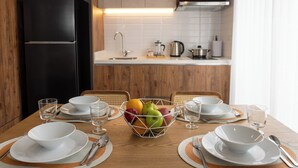 A modern kitchen with wooden cabinets, a black refrigerator, and a microwave. - Art Homes 85 (Bogotá)