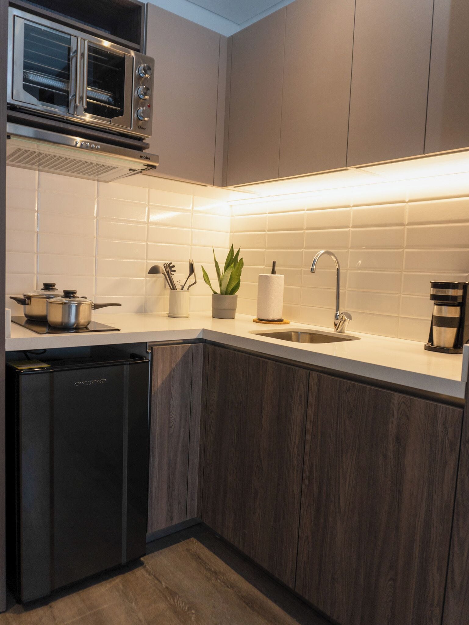 A modern kitchen with a built-in oven, microwave, and dishwasher.