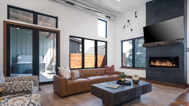 A modern living room with a leather sofa, a coffee table, and a fireplace.