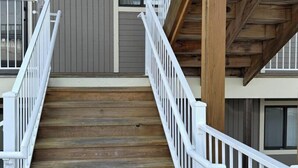 A wooden staircase with white railings leading to a second-floor balcony. - Lazy Days E-08 - Two Bedroom Apartment, Sleeps 6 (Osage Beach)