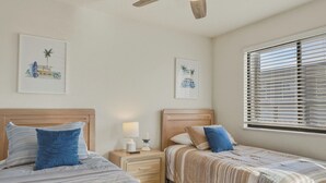 A bedroom with two beds, a nightstand with a lamp and remote, and a window with blinds. - Lazy Days E-08 - Two Bedroom Apartment, Sleeps 6 (Osage Beach)