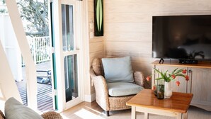 Una sala de estar acogedora con un sofá de mimbre, una mesa de centro de madera y un televisor de pantalla plana.