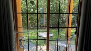 Una habitación con un gran ventanal corredero que da a un patio exterior con una mesa y sillas.