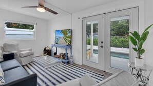 A modern living room with a sofa, a coffee table, a TV, and a bookshelf. - Holiday Lane - Discover the ultimate vacation retreat at Holiday Lane! (Naples)