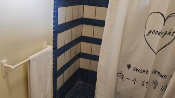 Een douche, handdoeken, zeep, shampoo