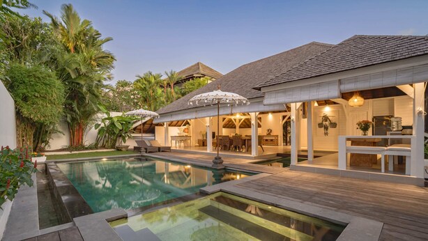 A pool area with a hot tub, wooden deck, and outdoor seating. - Villa Lou Ann (Canggu)