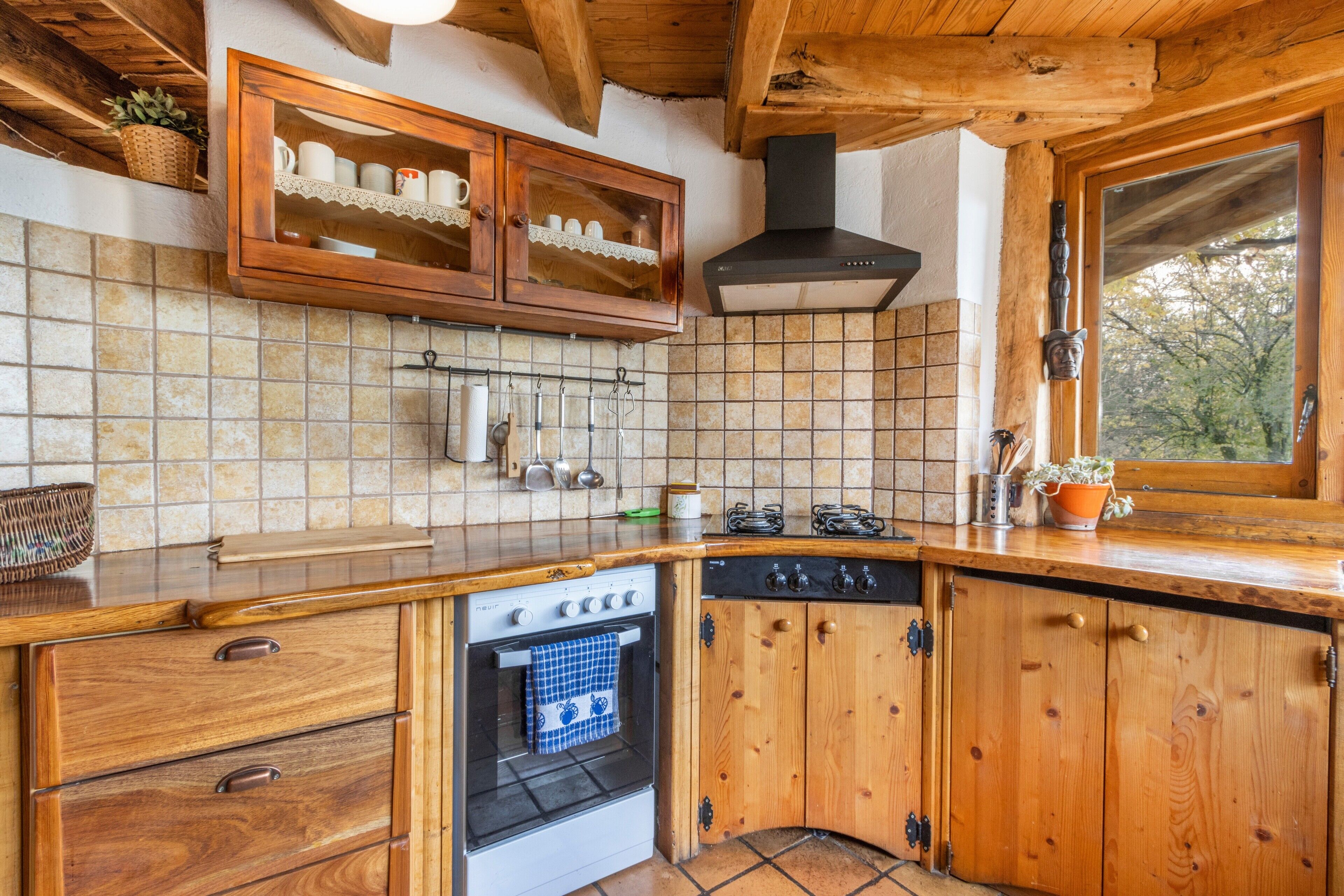 A wooden kitchen with a stove, oven, and cabinets.