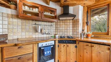 A wooden kitchen with a stove, oven, and cabinets.