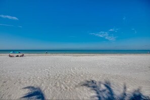 Ein Strand mit weißem Sand und blauem Himmel.